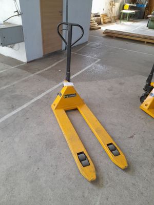 yellow forklifts in a warehouse with pallets in the background