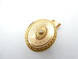 a gold locke with a pearl in it on a white surface