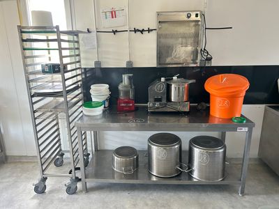 a kitchen with a stainless steel table with pots and pans on it