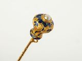 a close up of a gold stick with a blue and white flower on it