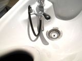 a white sink with a chrome faucet and a black faucet