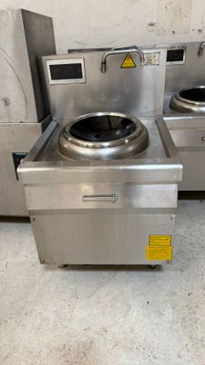 two stainless steel stoves sitting next to each other on the floor