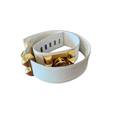 a white leather belt with gold studs on it