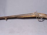 un vieux fusil avec une crosse en bois et un étui vert