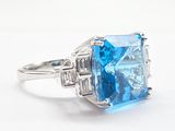 an image of a ring with a blue topaz stone surrounded by diamonds