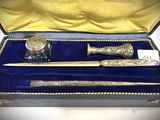 a silver pen and inkwell in a velvet case