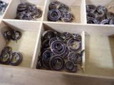 a wooden box filled with lots of different colored metal rings