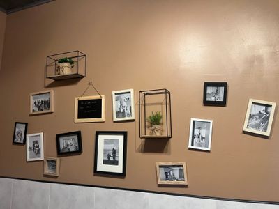 de nombreuses photos accrochées au mur au-dessus des toilettes dans la salle de bains