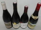 four bottles of wine are lined up on a table