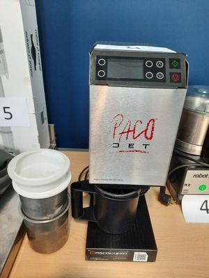 une cafetière posée sur une table à côté d'une tasse