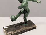statue of a baseball player on a marble base on a white surface