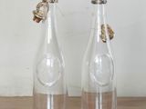 two empty glass bottles sitting on a wooden table