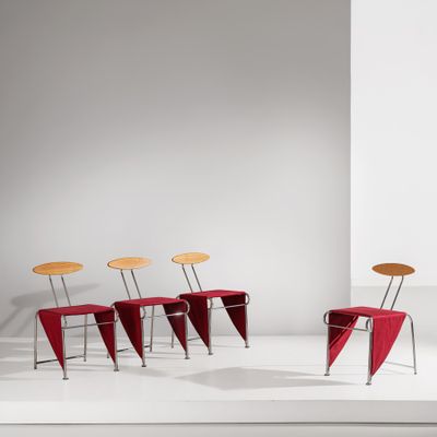 three chairs and a table in a white room with a white wall