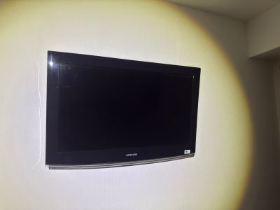 a flat screen tv mounted on the wall in the corner of a room