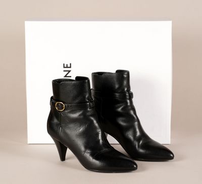 une paire de bottines en cuir noir ornées d'une boucle dorée