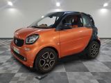 une Smart orange garée sur un sol à damier dans un showroom
