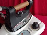 a black and white steam iron on a red cloth