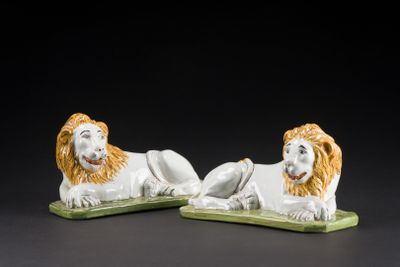 pair of white and orange lion figurines on green bases
