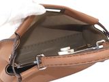 someone is holding a brown purse with a tissue in it