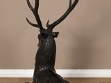 an image of a statue of a deer sitting on a wooden floor