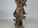statue en bronze représentant une femme tenant un enfant et un oiseau
