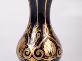 a blue and gold vase sitting on a white surface