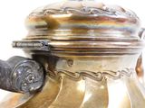 une théière en argent avec une anse sur une table