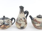 three pieces of pottery that are sitting on a white surface