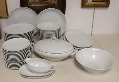 a lot of white plates and bowls on the table