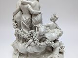 statue of a woman and two children sitting on a bed of flowers