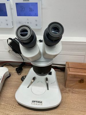 un microscope posé sur une table à côté d'un téléphone portable