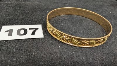 un gros plan d'un bracelet en or sur lequel figure un numéro