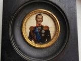 une petite photo représentant un homme en uniforme, dans un cadre noir