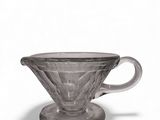 a close up of a glass coffee cup on a saucer