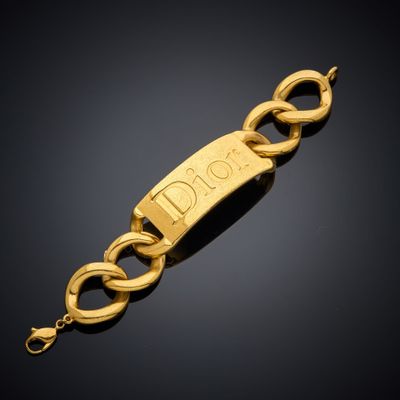 un bracelet en or sur lequel est gravé le mot « person »