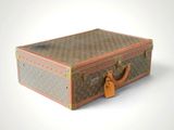 a brown and tan suitcase sitting on a white surface