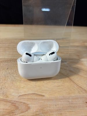 une boîte transparente contenant une paire d'AirPods, posée sur une table