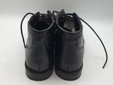black leather shoes with laces on them on a white surface