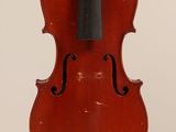 an old violin hanging from the back of a white wall
