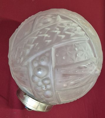 une boule de verre blanche posée sur un tissu rouge