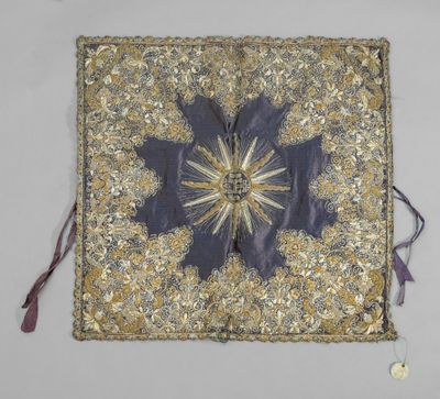 un coussin brodé et orné de perles, décoré d'un motif en forme d'étoile