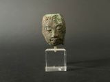 a close up of a sculpture of a head on a clear stand