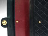 a close up of a black and red purse with a gold clasp