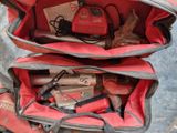 a red bag with tools inside of it on the ground