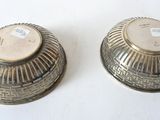 two silver vases sitting on a table with labels on them