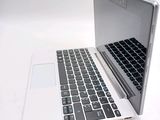 a white laptop with a black keyboard on a white surface