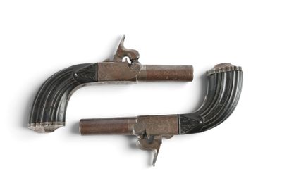 two old guns are on display on a white surface