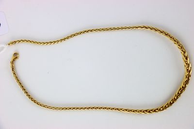 a close up of a gold chain on a white surface