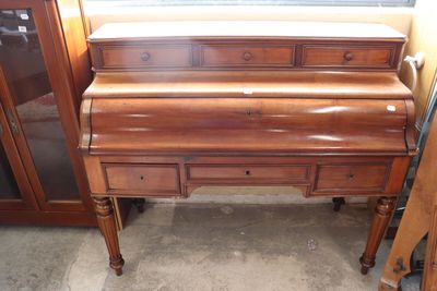 a wooden desk with drawers and a mirror in the corner