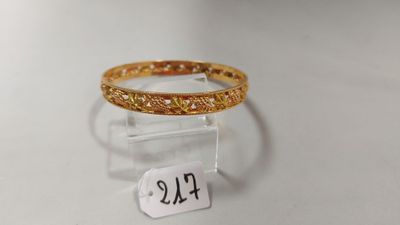 un gros plan d'une bague en or posée sur un socle transparent